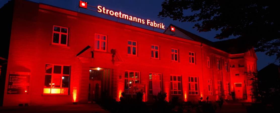 Strotmanns Fabrik Eingang rot beleuchtet